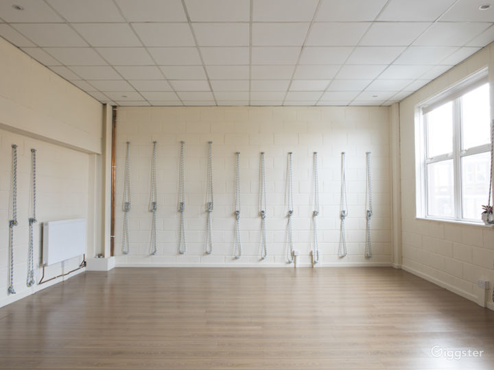 Light coloured room, high suspended ceiling, yoga wall ropes (can be removed)
