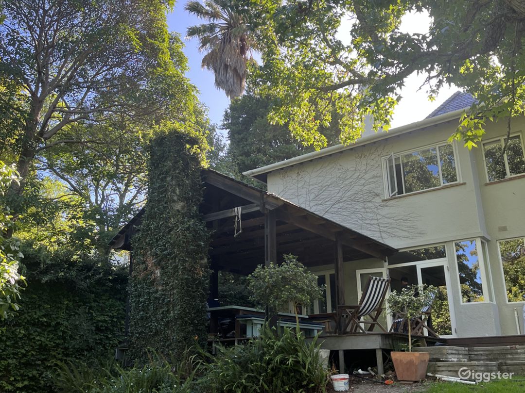 Back wooden deck with fold back windows leading into kitchen