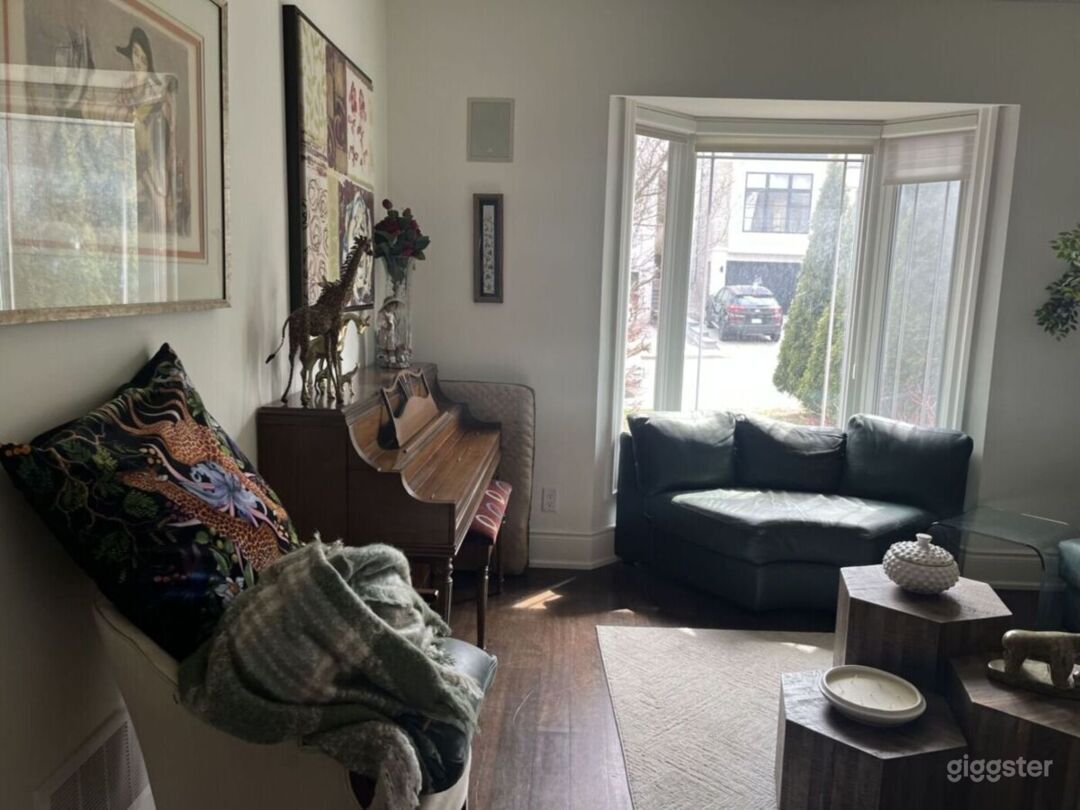 Main floor living room with piano and bay window