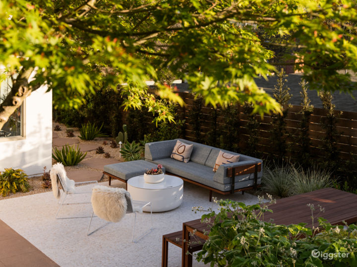 Ground floor of the patio featuring wooden Modernica table and sectional, as well as  the fire pit - with the lid on it acts as a coffee table